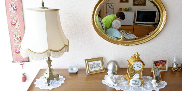 Eine Kommode mit altertümlicher Uhr und Lampe. Eine Kommode mit altertümlicher Uhr und Lampe.