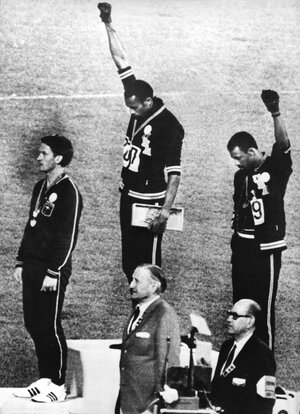 Tommie Smith (Mitte) und John Carlos bei den Olympischen Sommerspielen in Mexiko 1968 strecken bei der Siegerehrung ihre geballte Faust für die Bewegung «Black Power» Tommie Smith (Mitte) und John Carlos bei den Olympischen Sommerspielen in Mexiko 1968 strecken bei der Siegerehrung ihre geballte Faust für die Bewegung «Black Power»