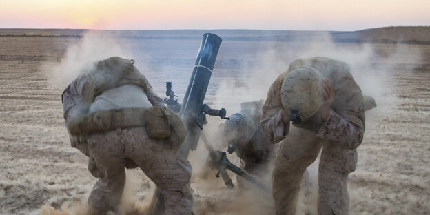 Drei Soldaten halten sich während einer Explosion die Ohren zu Drei Soldaten halten sich während einer Explosion die Ohren zu