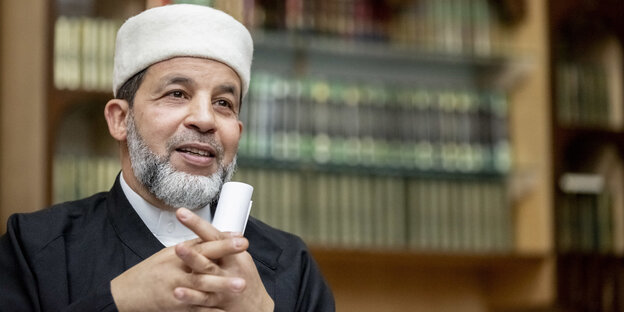 Mohamed Taha Sabri ist der Imam der Moschee des Vereins Neuköllner Begegnungsstätte - vor einem Regal mit Büchern zu sehen Mohamed Taha Sabri ist der Imam der Moschee des Vereins Neuköllner Begegnungsstätte - vor einem Regal mit Büchern zu sehen