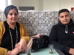 Eine Frau und ein junger Mann an einem Küchentisch Eine Frau und ein junger Mann an einem Küchentisch