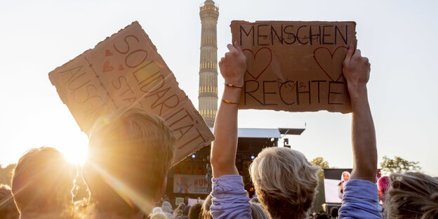 Schilder mit der Aufschrift Solidarität und Menschenrechte vor der Siegessäule Schilder mit der Aufschrift Solidarität und Menschenrechte vor der Siegessäule