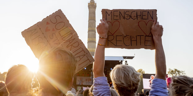 Schilder mit der Aufschrift Solidarität und Menschenrechte vor der Siegessäule