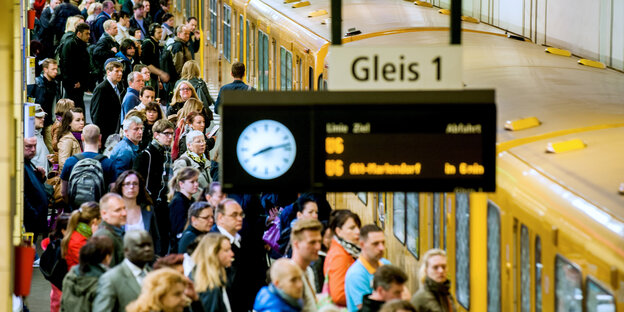 Das Bild zeigt viele Menschen, die sich auf einem Berliner U-Bahnhof vor einer einfahrenden U-Bahn drängeln.