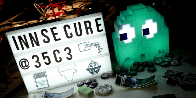 Ein Modell einer Videospielfigur schaut auf eine Anzeige auf dem "Innsecure 35c3" steht Ein Modell einer Videospielfigur schaut auf eine Anzeige auf dem "Innsecure 35c3" steht