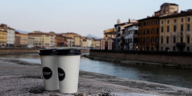 Szene am Arno in Pisa: Zwei Kaffeebecher vor dem Fluss Szene am Arno in Pisa: Zwei Kaffeebecher vor dem Fluss