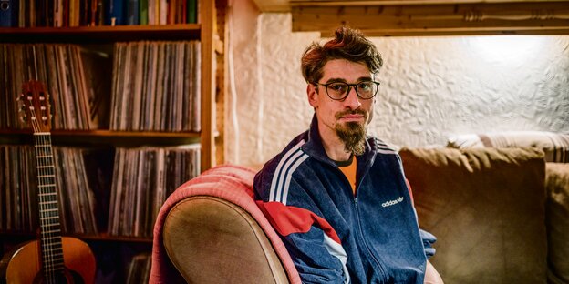 Johannes M. sitzt vor einem Regal mit Schallplatten. Johannes M. sitzt vor einem Regal mit Schallplatten.