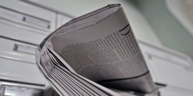 Eine Zeitung steckt in einem Briefkasten Eine Zeitung steckt in einem Briefkasten