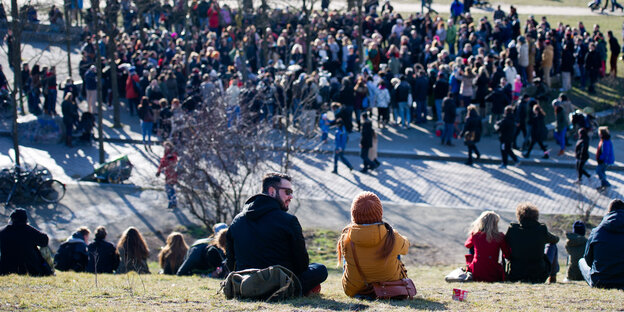 Das Foto zeigt eine Menschenmenge, die im Mauerpark in Berlin-Mitte Straßenmusikern lauscht. Das Foto zeigt eine Menschenmenge, die im Mauerpark in Berlin-Mitte Straßenmusikern lauscht.