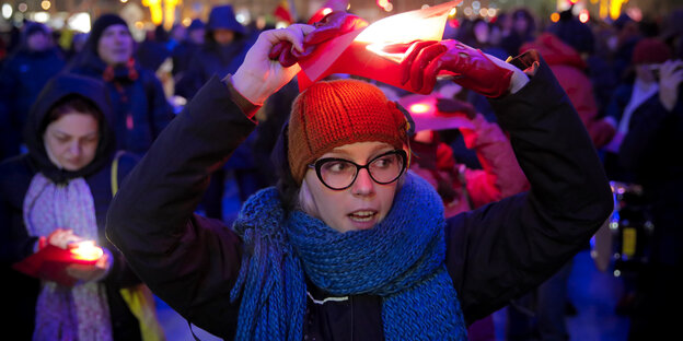 Eine Frau hält bei einem Protest gegen die Regierung ein rotes Stück Papier, um die rot-gelb-blaue Flagge Rumäniens nachzustellen Eine Frau hält bei einem Protest gegen die Regierung ein rotes Stück Papier, um die rot-gelb-blaue Flagge Rumäniens nachzustellen
