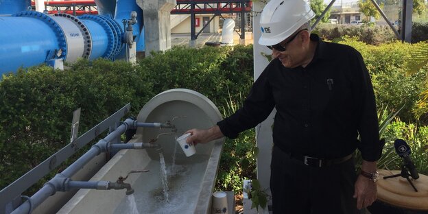 Technikchef Boris Libermann füllt Wasser aus der Entsalzungsanlage ab Technikchef Boris Libermann füllt Wasser aus der Entsalzungsanlage ab