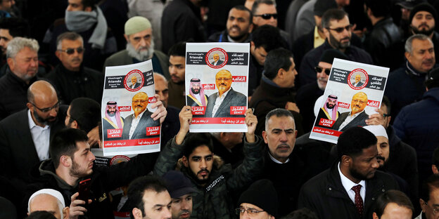 Männer halten Poster hoch, auf denen Jamal Khashoggi zu sehen ist Männer halten Poster hoch, auf denen Jamal Khashoggi zu sehen ist