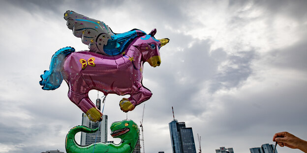 Ein rosa Einhorn-Luftballon vor bewölktem Himmel Ein rosa Einhorn-Luftballon vor bewölktem Himmel