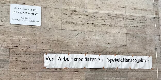 An einer Wand in der Karl-Marx-Allee klebt ein Spruch: Von Arbeiterpalästen zu Spekulationsobjekten An einer Wand in der Karl-Marx-Allee klebt ein Spruch: Von Arbeiterpalästen zu Spekulationsobjekten