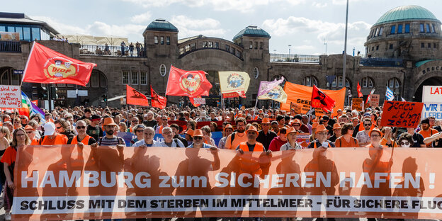 Demonstrierende mit Transparenten vor Hamburger Landungsbrücken Demonstrierende mit Transparenten vor Hamburger Landungsbrücken
