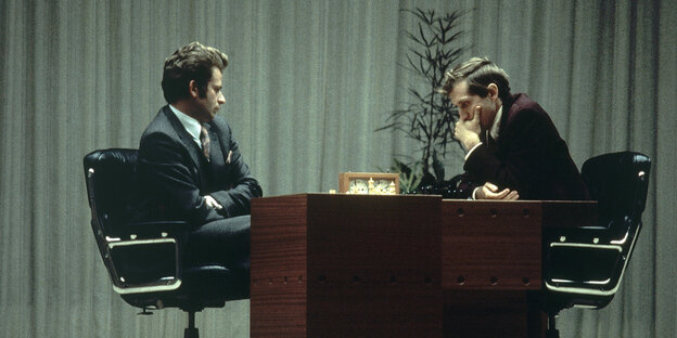 Boris Spasski und Bobby Fischer sitzen sich gegenüber, in der Mitte steht ein Tisch mit einem Schachbrett Boris Spasski und Bobby Fischer sitzen sich gegenüber, in der Mitte steht ein Tisch mit einem Schachbrett
