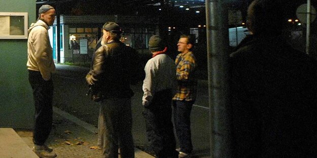 Männer stehen vor einem Gebäude Männer stehen vor einem Gebäude