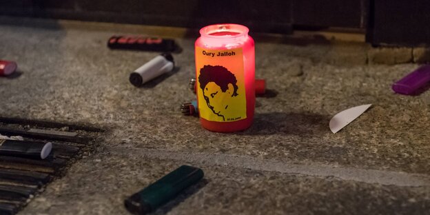 Feuerzeuge neben einer Kerze, auf der Oury Jarohs Gesicht zu sehen ist Feuerzeuge neben einer Kerze, auf der Oury Jarohs Gesicht zu sehen ist