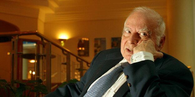 Norman Birnbaum sitzt im Anzug in einem Raum und stützt den Kopf auf seine linke Hand Norman Birnbaum sitzt im Anzug in einem Raum und stützt den Kopf auf seine linke Hand