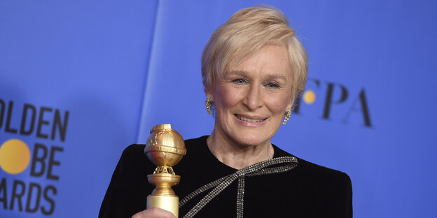 Frau hält goldene Trophäe in der Hand Frau hält goldene Trophäe in der Hand