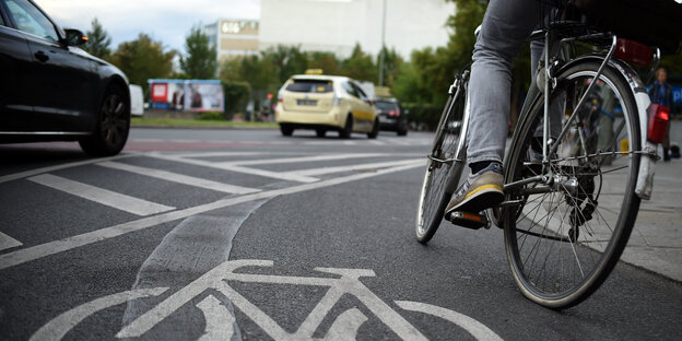 Autos und ein Radler an einem Kreisverkehr Autos und ein Radler an einem Kreisverkehr