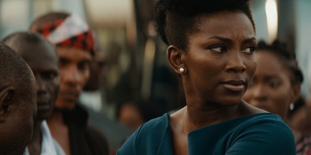 Szene aus dem Netflix-Film „Lionheart“, eine Frau ist im Fokus, umringt von Menschen Szene aus dem Netflix-Film „Lionheart“, eine Frau ist im Fokus, umringt von Menschen