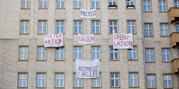 An einer Gebäudefassade hängen Transparente, u.a. „Protest“ und „Mieteraktion gegen Spekulation“ An einer Gebäudefassade hängen Transparente, u.a. „Protest“ und „Mieteraktion gegen Spekulation“