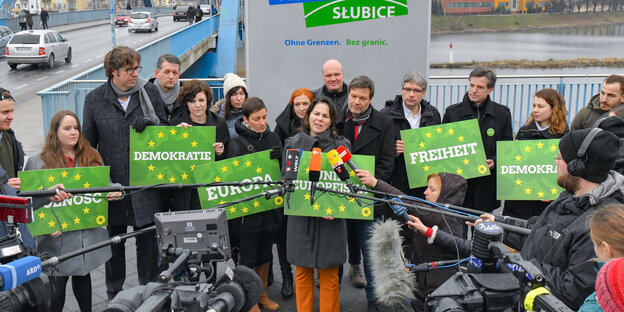 Annelena Baerbock steht vor Mikrofonen, daneben andere Spitzengrüne mit Plakaten wie "Demokratie", "Europa" und "Freiheit" Annelena Baerbock steht vor Mikrofonen, daneben andere Spitzengrüne mit Plakaten wie "Demokratie", "Europa" und "Freiheit"