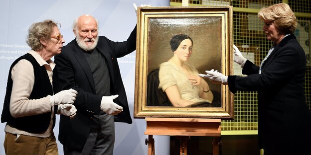 Kulturstaatsministerin Monika Grütters übergibt den Erben Maria de las Mercedes Estrada und Wolfgang Kleinertz, das Bild "Portrait de jeune femme assise" des Künstlers Thomas Couture Kulturstaatsministerin Monika Grütters übergibt den Erben Maria de las Mercedes Estrada und Wolfgang Kleinertz, das Bild "Portrait de jeune femme assise" des Künstlers Thomas Couture