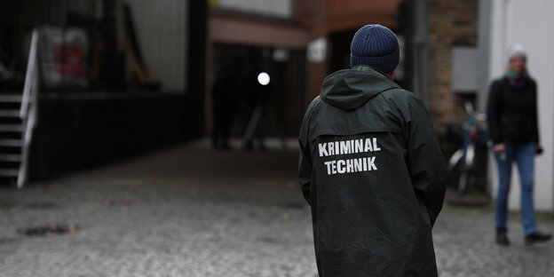 Ein Mensch steht vor einer Einfahrt. Auf der Jacke steht "Kriminaltechnik" Ein Mensch steht vor einer Einfahrt. Auf der Jacke steht "Kriminaltechnik"