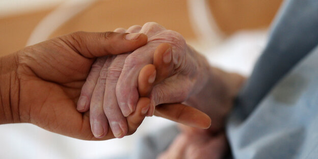 Eine junge Hand hält eine alte Hand Eine junge Hand hält eine alte Hand