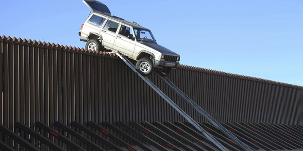 Ein Jeep hängt an der Mauer an der US-mexikanischen Grenzmauer fest Ein Jeep hängt an der Mauer an der US-mexikanischen Grenzmauer fest