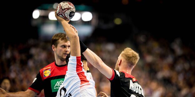Ein südkoreanischer Handball wird von zwei deutschen am Wurf gehindert Ein südkoreanischer Handball wird von zwei deutschen am Wurf gehindert