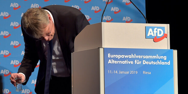 Jörg Meuthen schaut neben einem Rednerpult auf den Boden