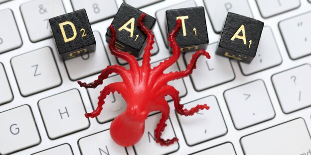 Ein Spielzeug-Krake sitzt auf einer Computertastatur Ein Spielzeug-Krake sitzt auf einer Computertastatur