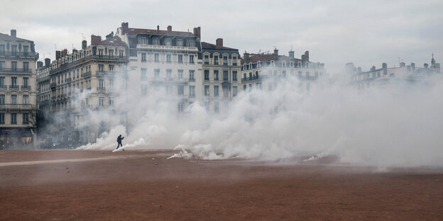 Ein Mann geht durch eine Tränengaswolke bei Auseinandersetzungen mit der Polizei in Lyon
