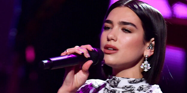Die Sängerin Dua Lipa singt in ein Mikrofon Die Sängerin Dua Lipa singt in ein Mikrofon