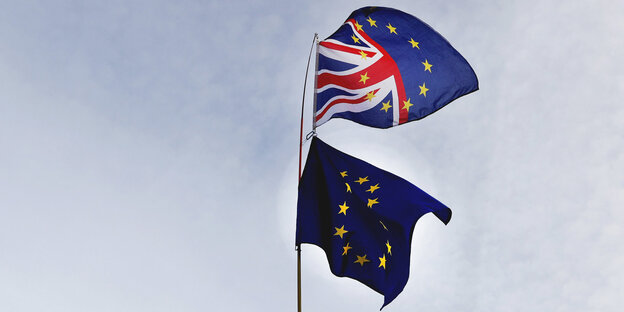 Eine britische und eine europäische Flagge wehen im Wind Eine britische und eine europäische Flagge wehen im Wind