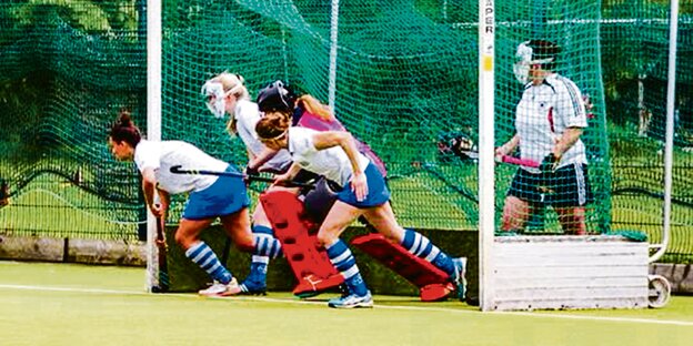 Hockeyspielerinnen auf einem Hockey-Spielfeld.