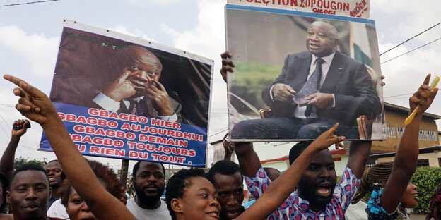 Demonstranten halten Plakate des früheren ivorischen Präsidenten Gbagbo hoch Demonstranten halten Plakate des früheren ivorischen Präsidenten Gbagbo hoch