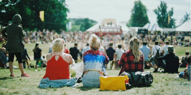 Menschen sitzen auf einer Wiese Menschen sitzen auf einer Wiese