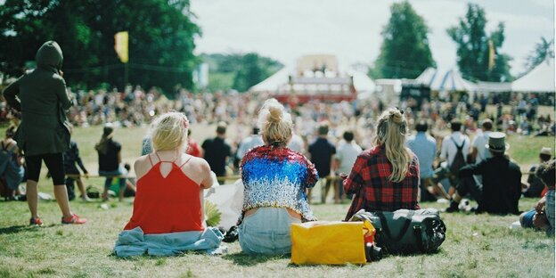 Menschen sitzen auf einer Wiese