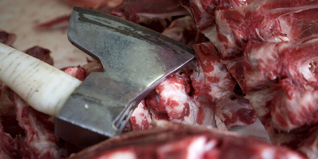 Eine Axt liegt neben rohem Fleisch. Eine Axt liegt neben rohem Fleisch.