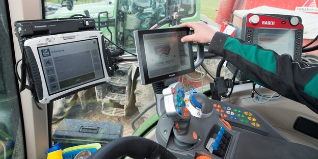 Computer-Bildschirme im Fahrerhaus eines Traktors Computer-Bildschirme im Fahrerhaus eines Traktors