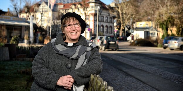 Judith Gigl steht gegen einen Zaun gelehnt auf einem Gehweg Judith Gigl steht gegen einen Zaun gelehnt auf einem Gehweg