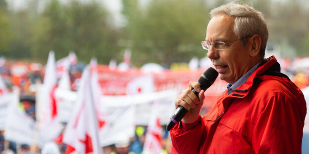 Mann spricht mit Mikro vor Demonstranten Mann spricht mit Mikro vor Demonstranten