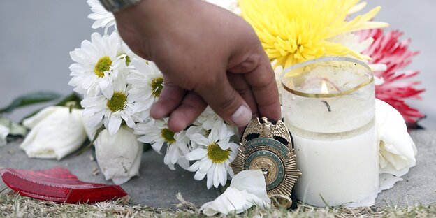 Eine Hand, eine Kerze und Blumen Eine Hand, eine Kerze und Blumen