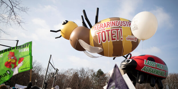 Demo "Wir haben es satt" in Berlin. Auf einem Bieneballon steht "Agrarindustrie tötet" Demo "Wir haben es satt" in Berlin. Auf einem Bieneballon steht "Agrarindustrie tötet"