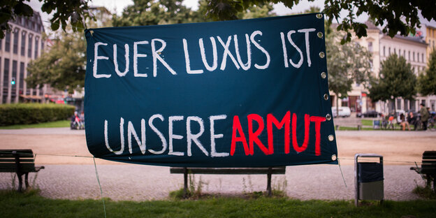 Transparent, auf dem steht: Euer Luxus ist unsere Armut