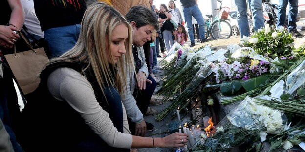 Menschen legen zum Gedenken Blumen nieder Menschen legen zum Gedenken Blumen nieder